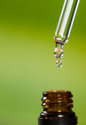 drop-oil-dripping-from-pipette-into-bottle-essential-oil